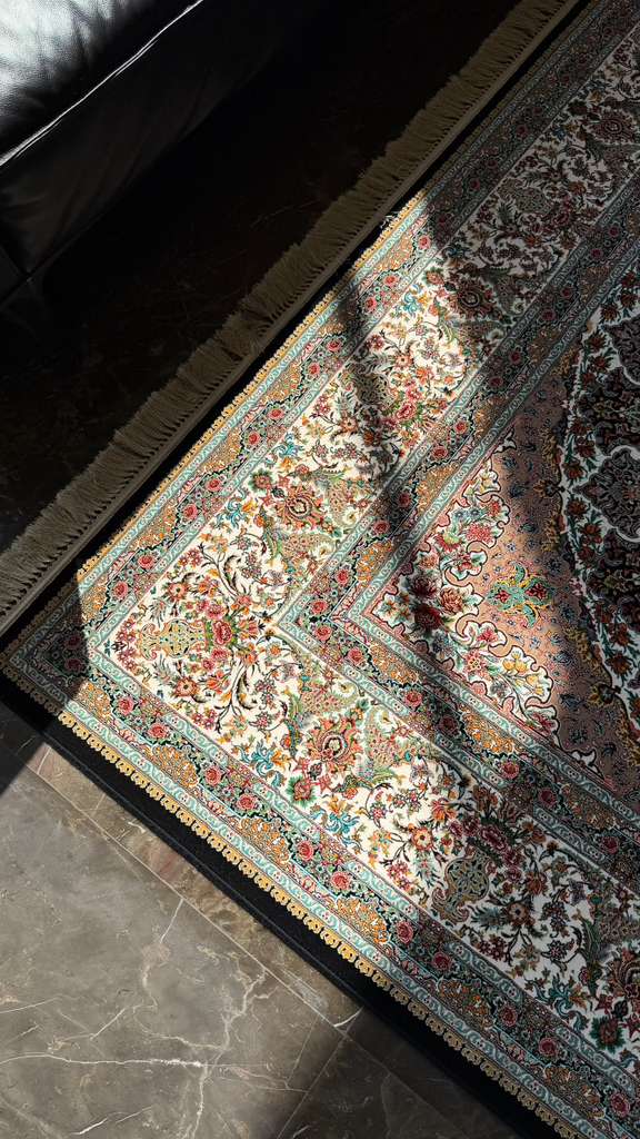 Detalle de tapete persa Safron Rugs con motivos florales sobre piso de mármol
